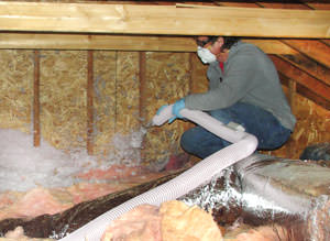 an HVAC expert installing attic insulation in a home in Danbury